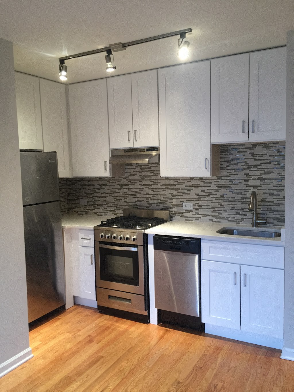 a kitchen with white cabinets and a stove and a refrigerator