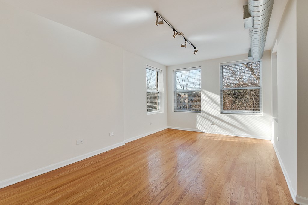 an empty living room with white walls and wood floors