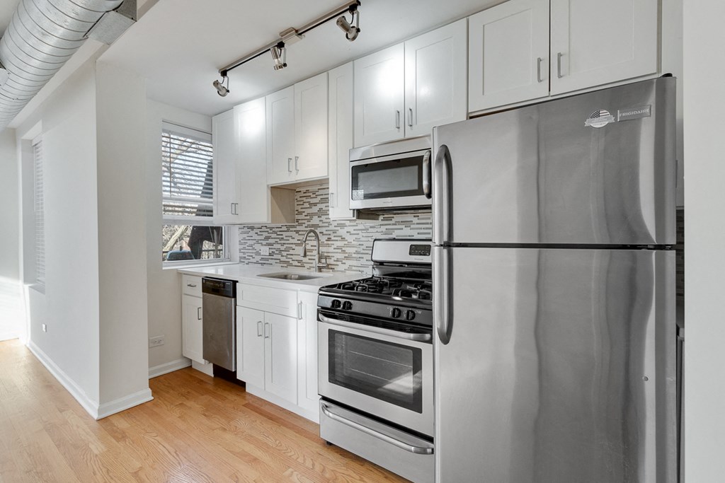 a kitchen with stainless steel appliances and white cabinets