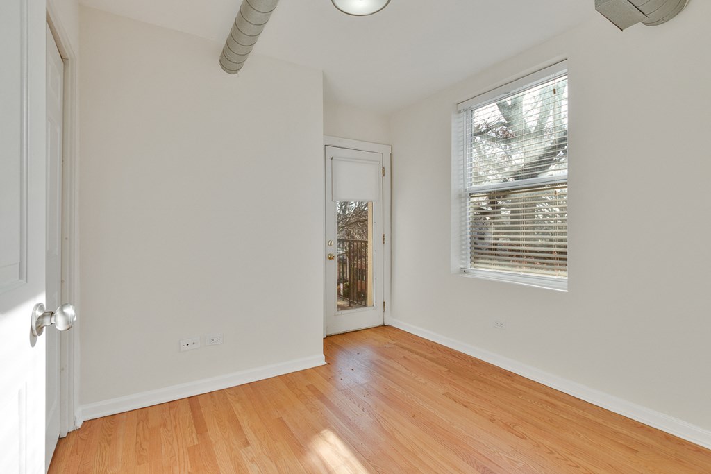 an empty room with wood floors and a window