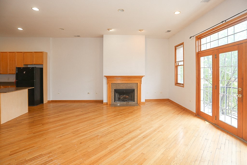 an empty living room with wood floors and a fireplace