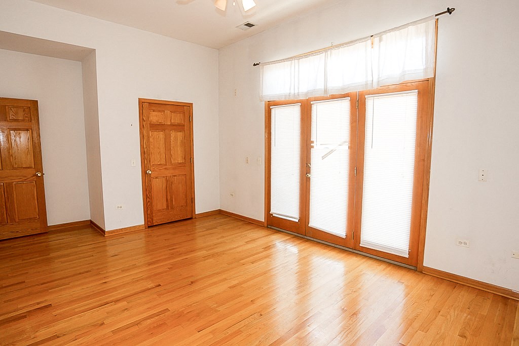 an empty living room with wood floors and white walls
