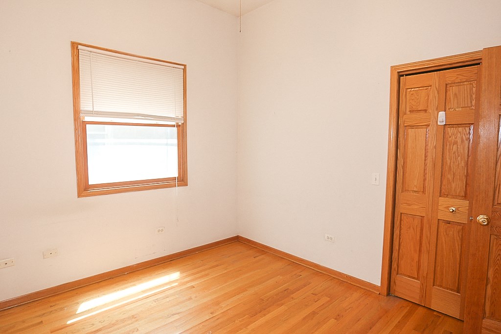 an empty room with wooden floors and a window and a door