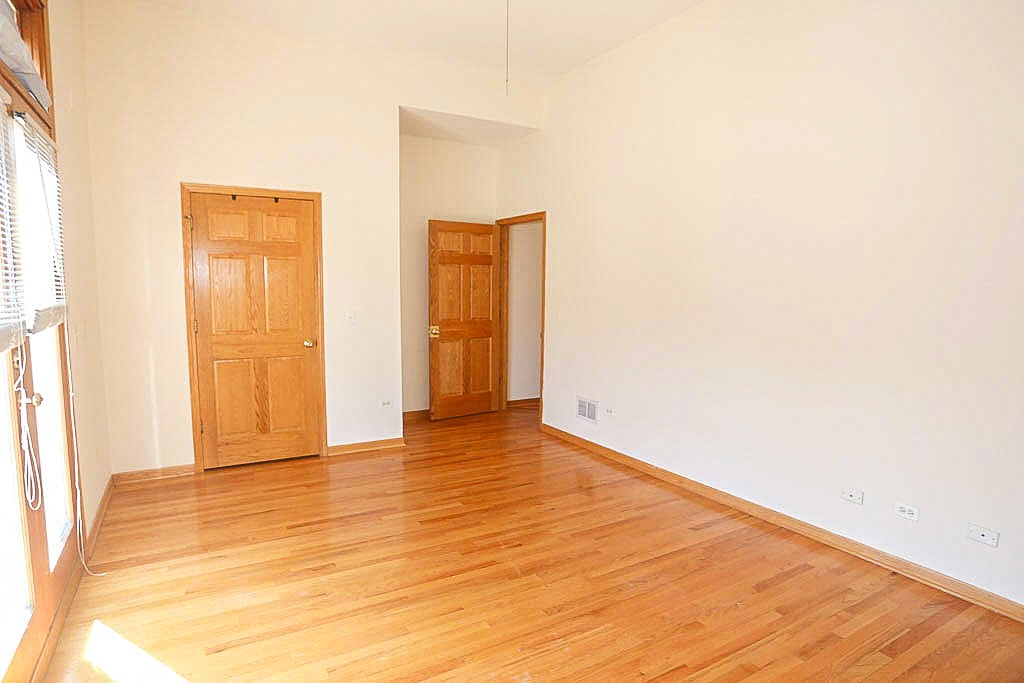 an empty living room with wood floors and a door