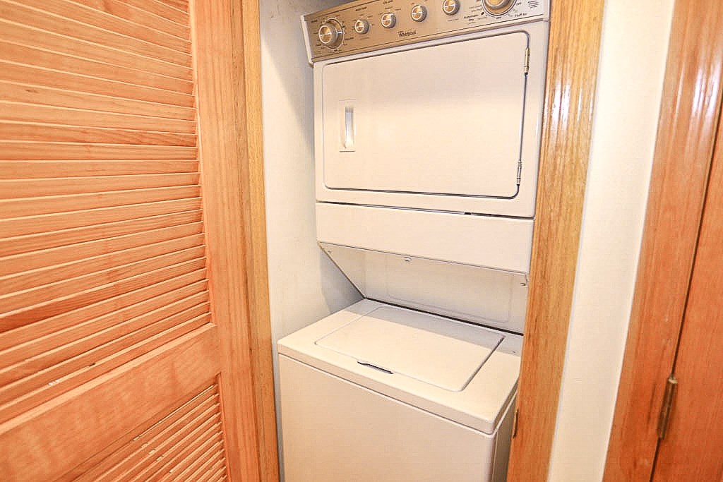 a white washer and dryer in a wooden closet