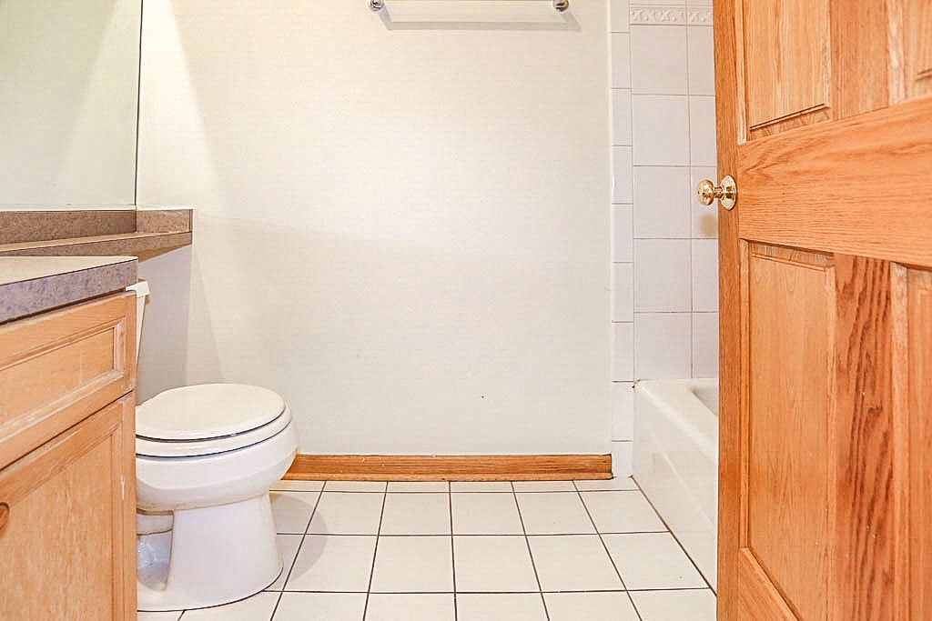 a white bathroom with a toilet and a shower