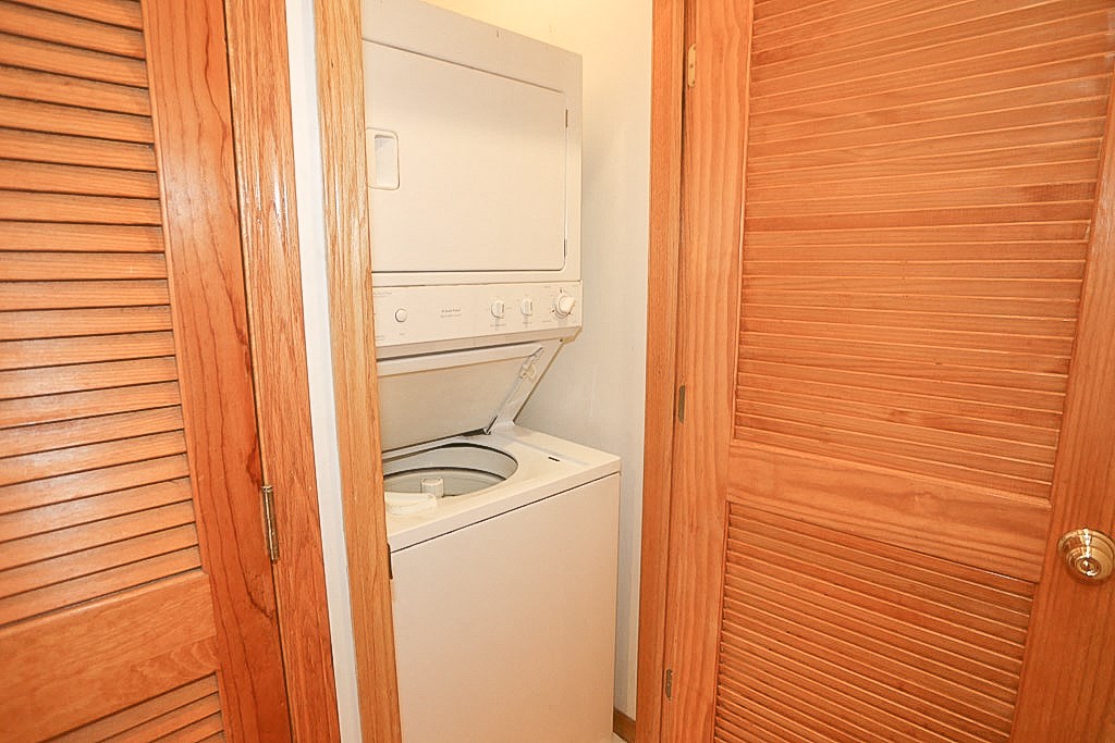 the laundry room has a washer and dryer and a wooden door