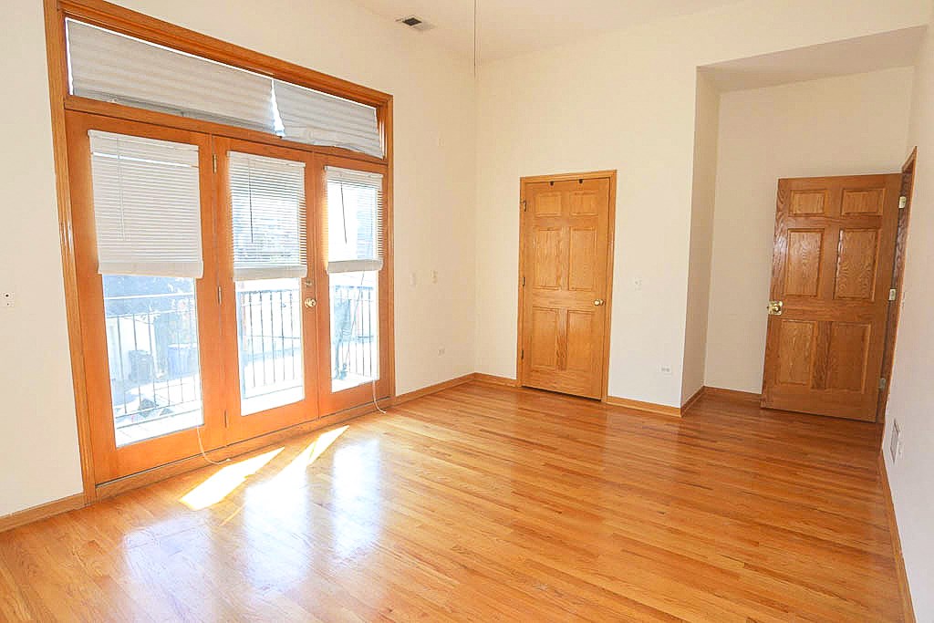 an empty living room with wood floors and doors