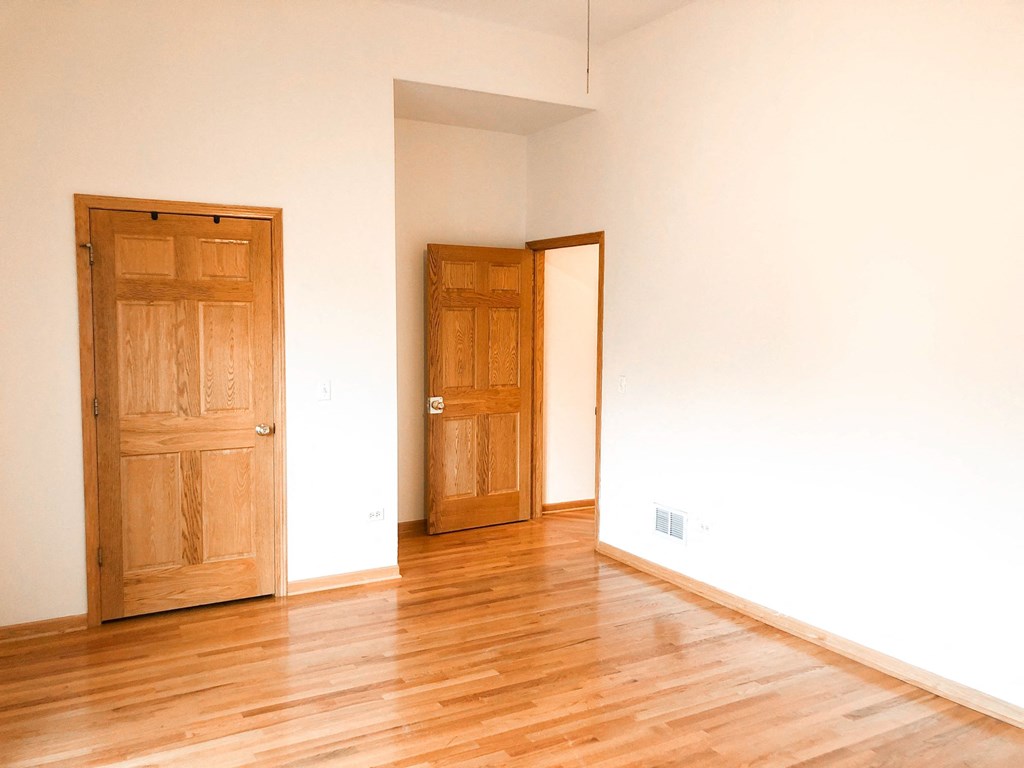 an empty room with wooden floors and two doors