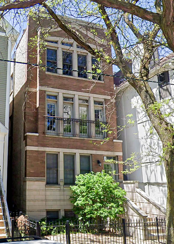 a tall brick building with a tree in front of it