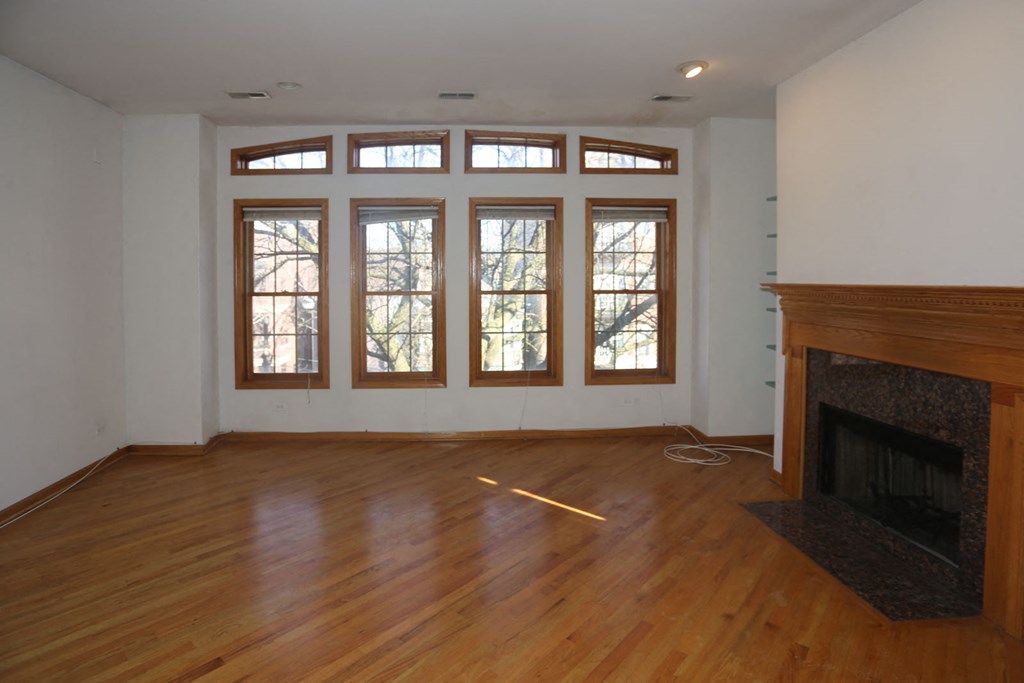 a living room with a fireplace and a wooden floor