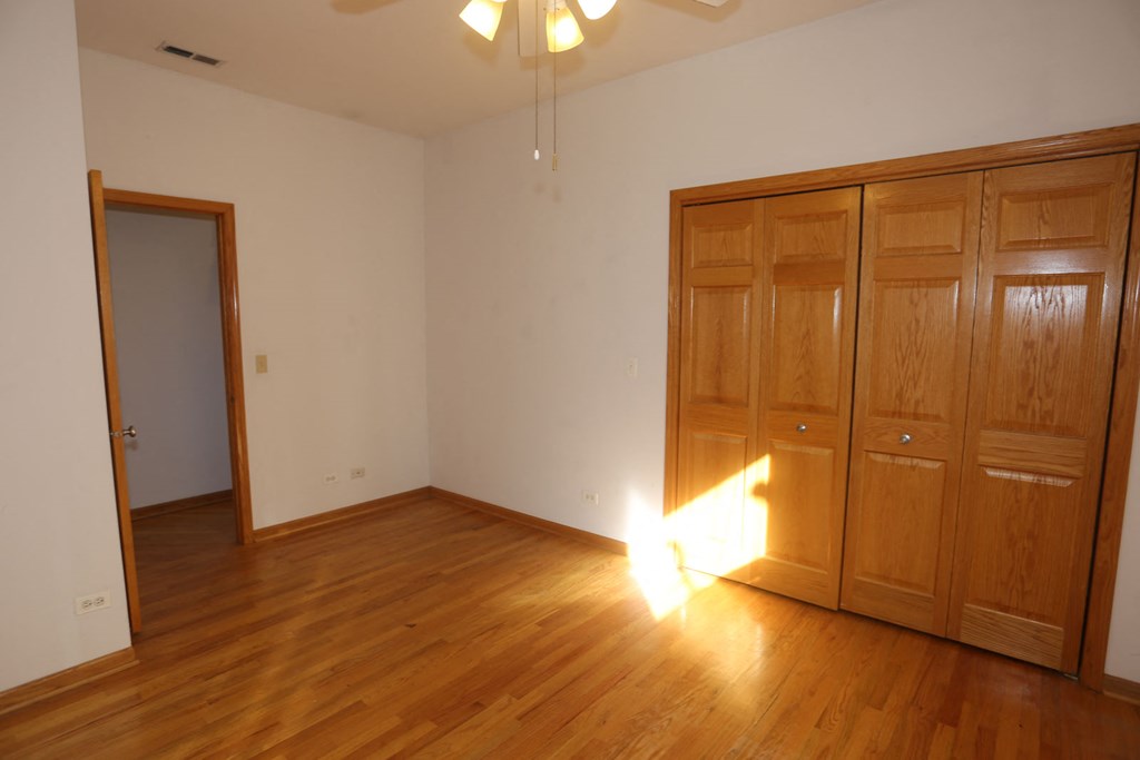 an empty living room with wooden floors and a closet
