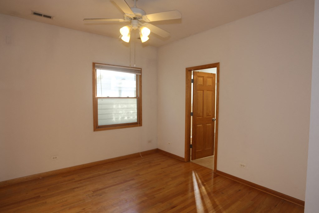an empty living room with a ceiling fan and a window