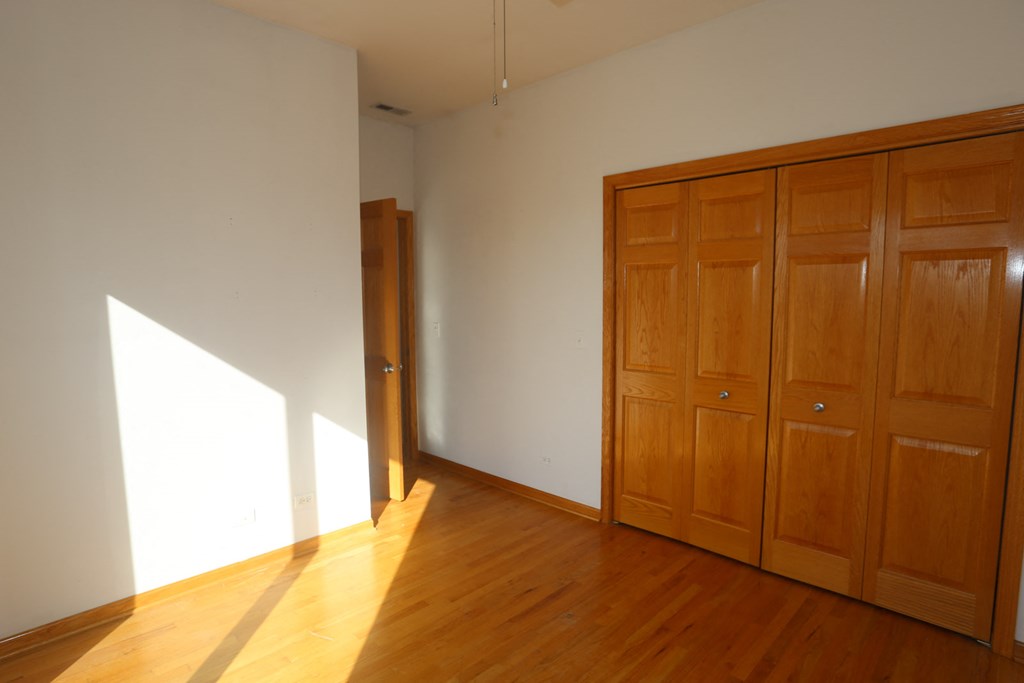 an empty room with wood floors and wooden closets
