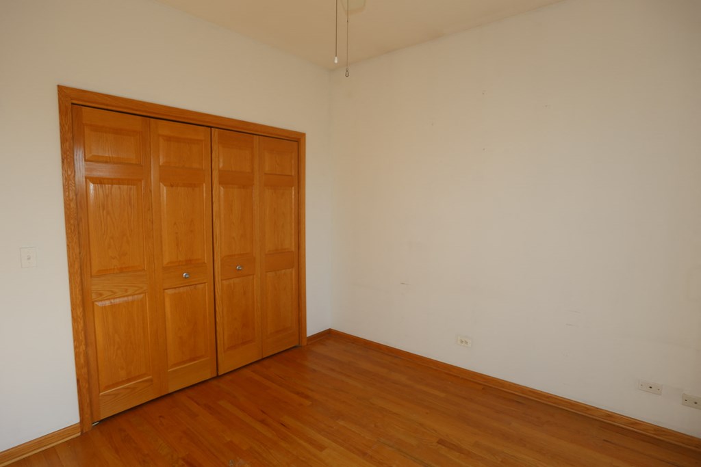 an empty room with wooden floors and a closet