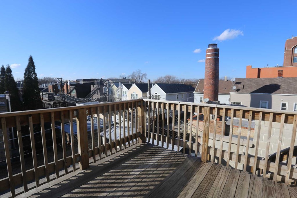 a balcony with a view of a city and a wooden railing