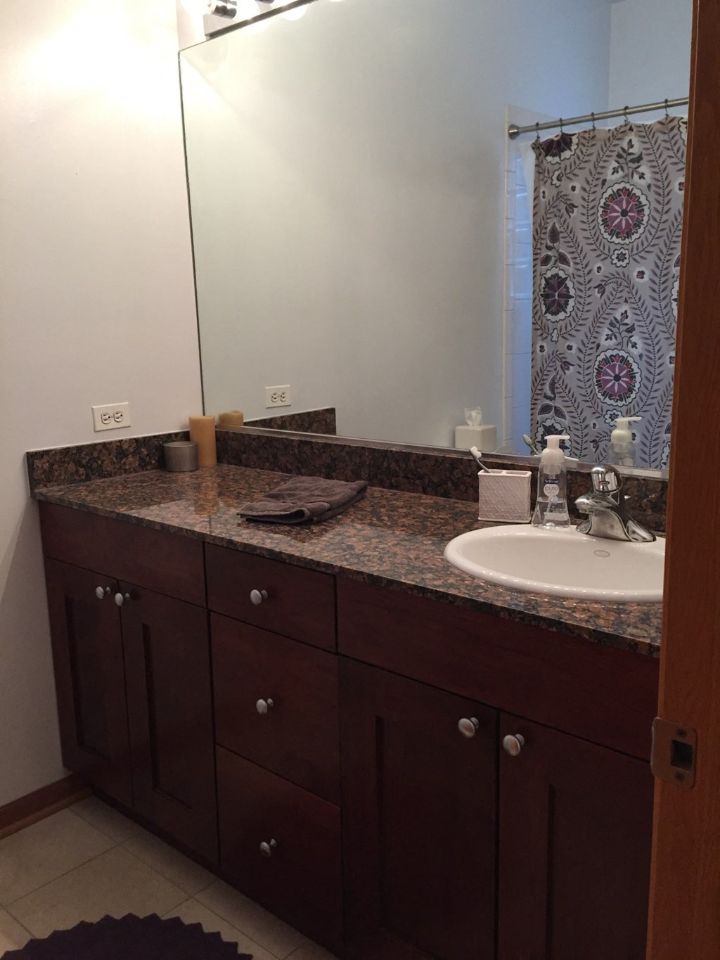 the bathroom has a granite counter top and a sink