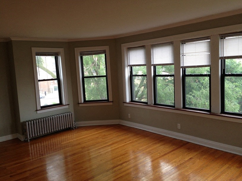a living room with a wood floor and large windows
