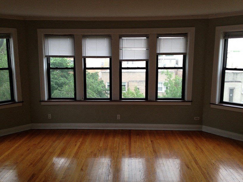 a living room with a wood floor and a row of windows