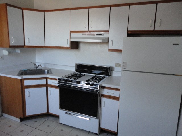 an empty kitchen with a stove and a refrigerator