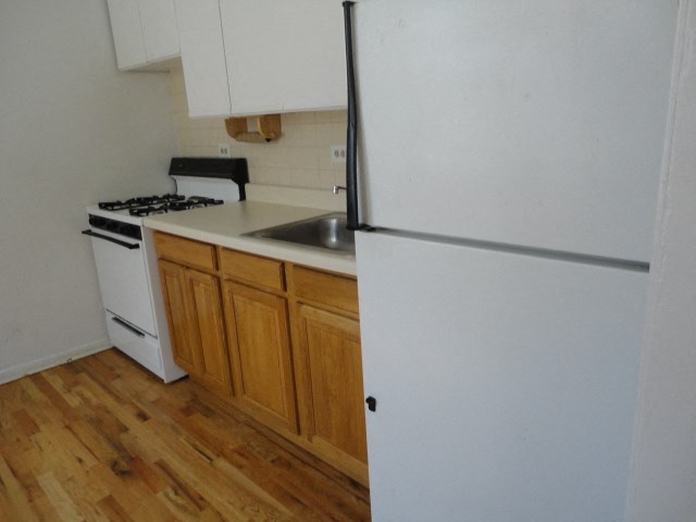 an empty kitchen with a stove and refrigerator
