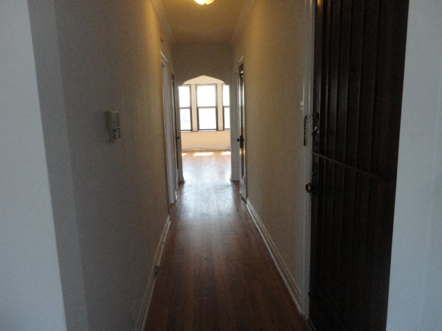 a hallway with a wood floor and a window
