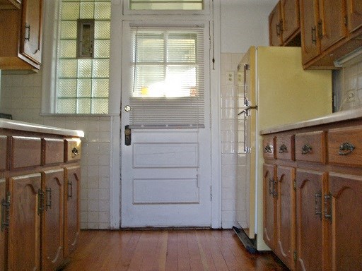 a kitchen with wooden cabinets and a white door
