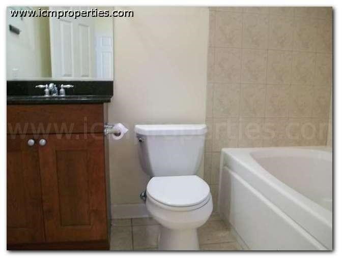 a bathroom with a white toilet and a bath tub
