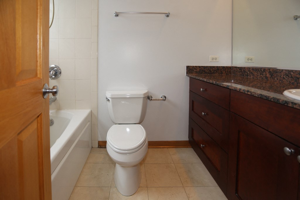 a bathroom with a toilet and a tub and a sink
