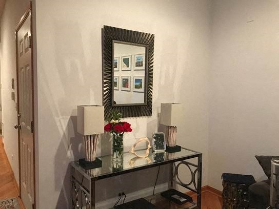 a living room with a mirror and a table with flowers