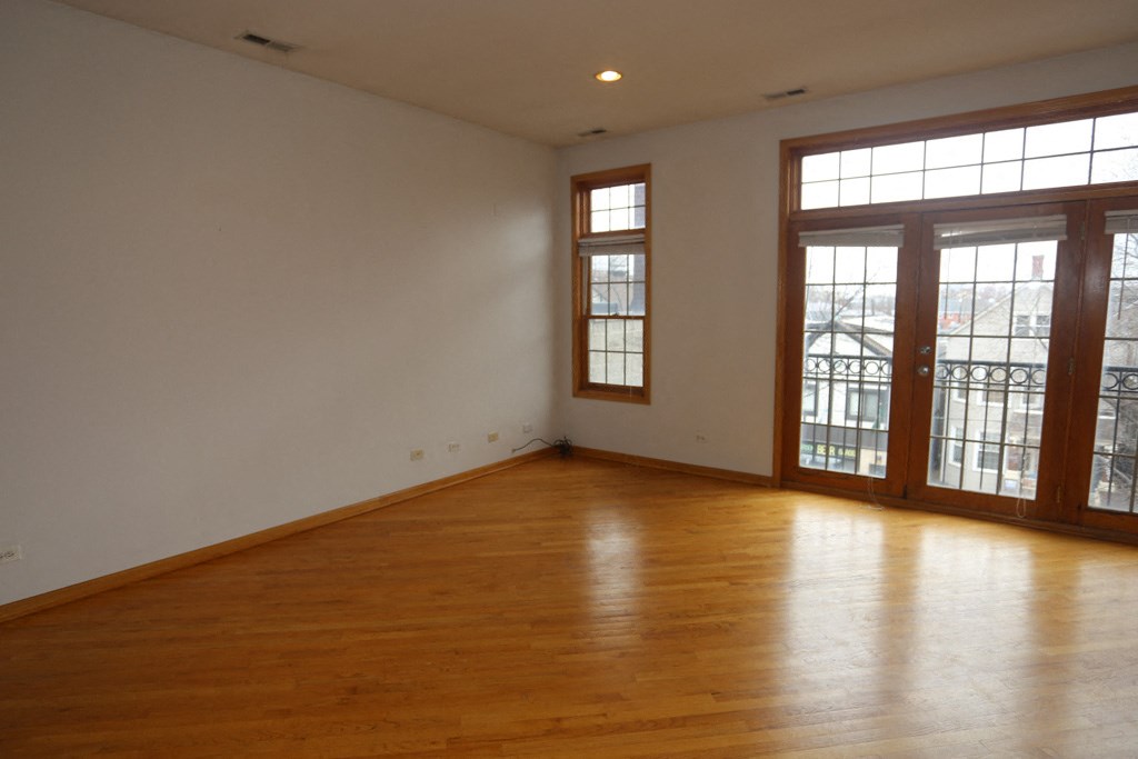 an empty living room with wood floors and windows