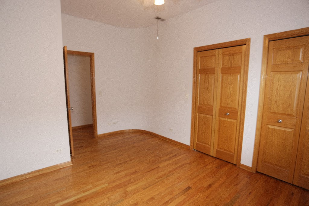 an empty room with wooden floors and two doors