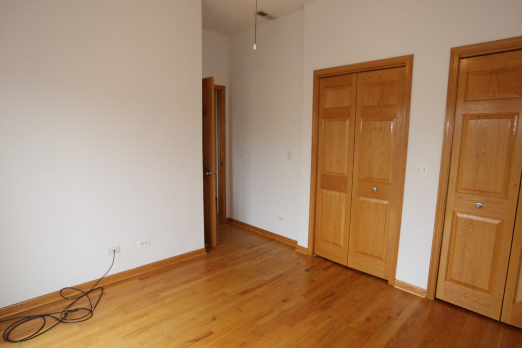 an empty room with wooden floors and two doors