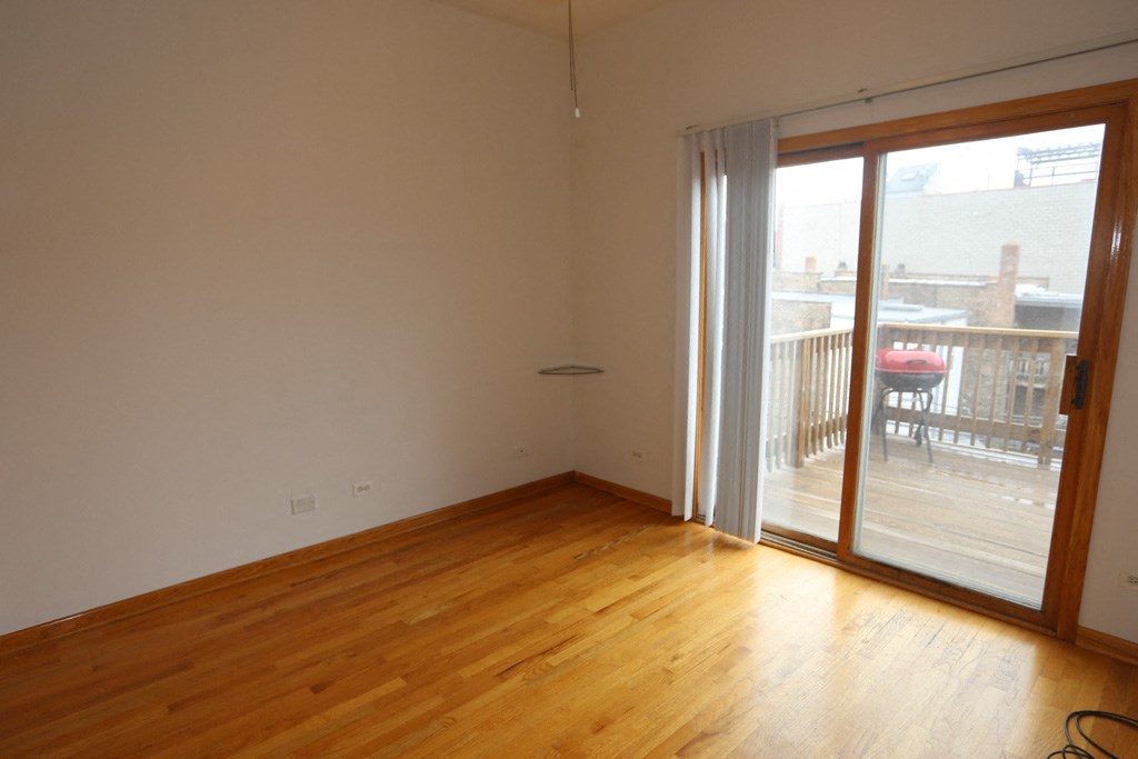 an empty living room with a sliding glass door to a balcony