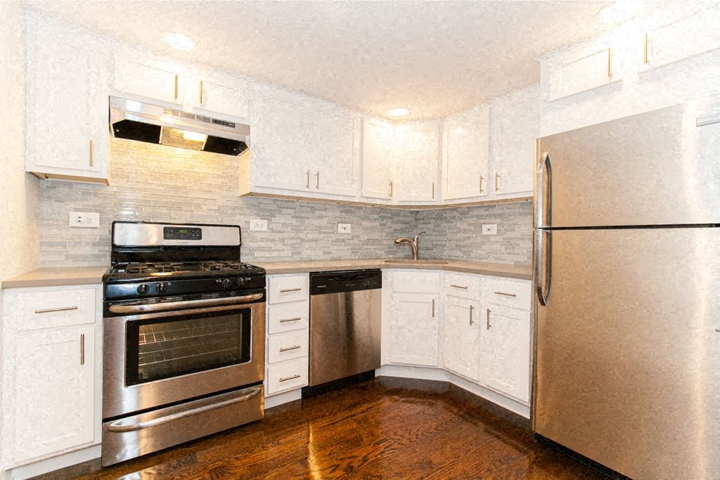 a kitchen with stainless steel appliances and white cabinets