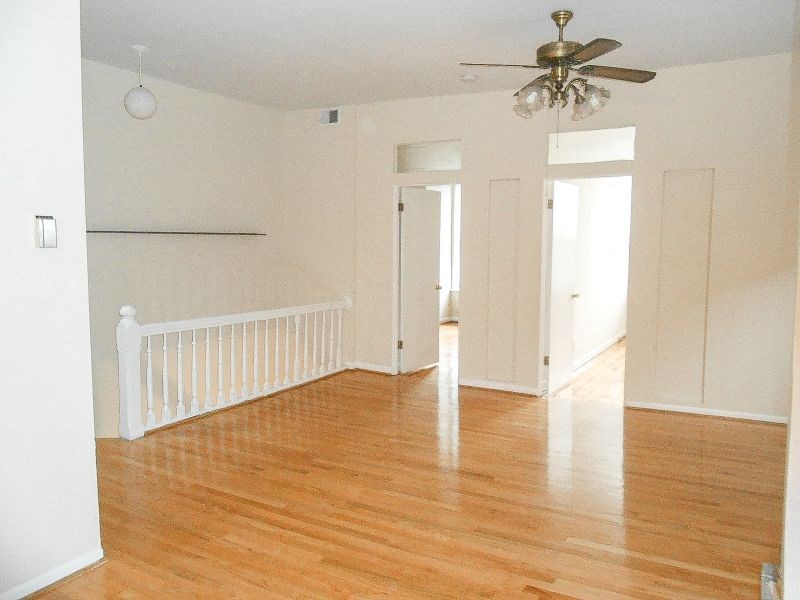 an empty room with a ceiling fan and wood floors