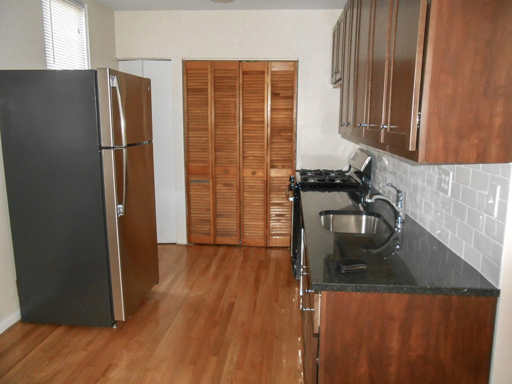 a kitchen with wooden floors and a refrigerator