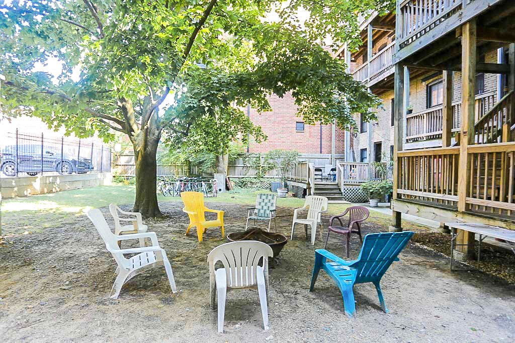 a group of chairs sitting in a yard next to a tree