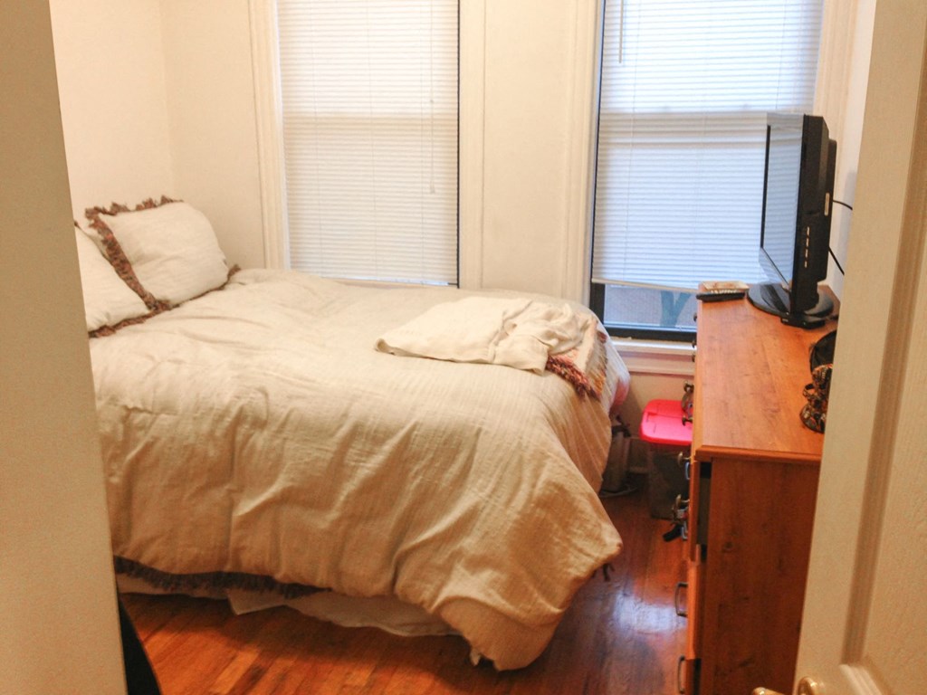 a small bedroom with a bed and a tv