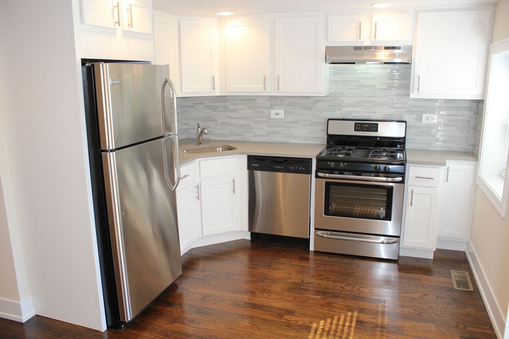 a kitchen with stainless steel appliances and white cabinets