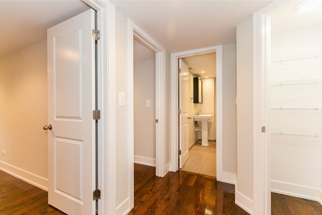 a bedroom with a door open to a hallway and a bathroom