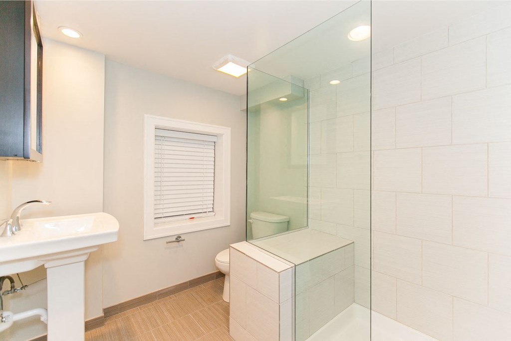 a bathroom with a shower and a sink and a toilet