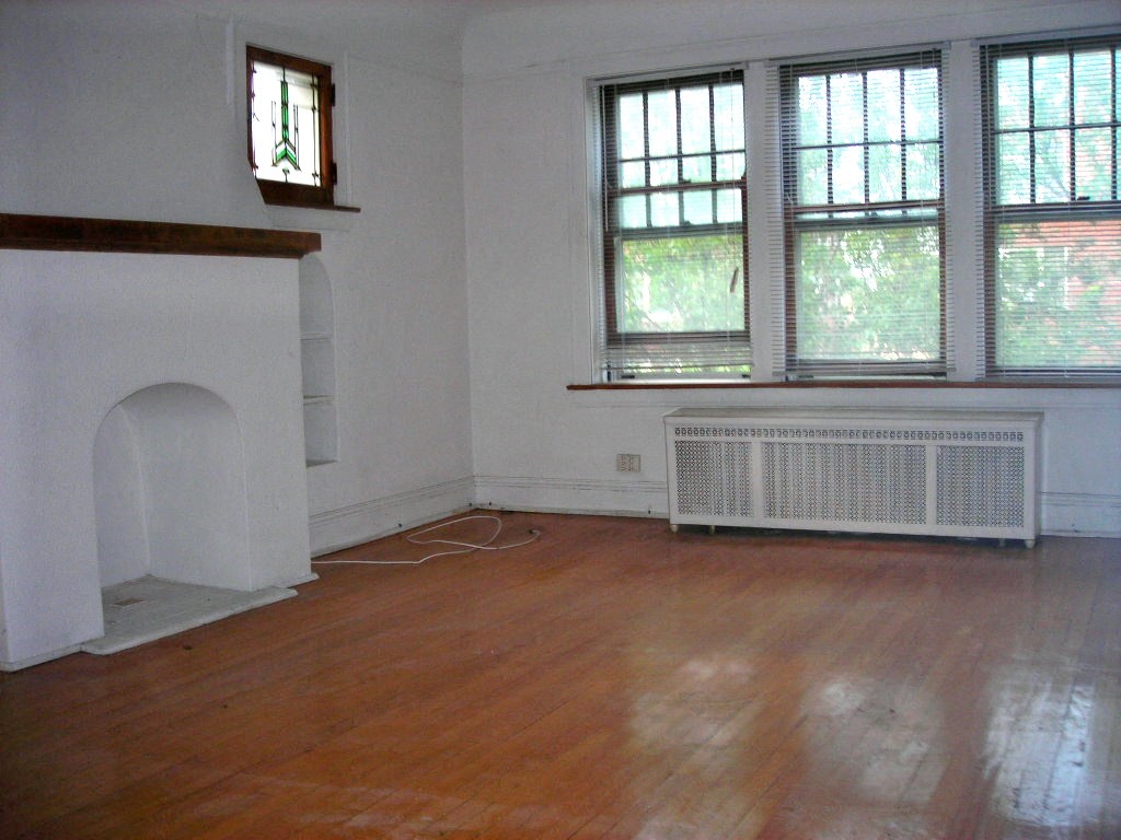 an empty living room with wood floors and a fireplace
