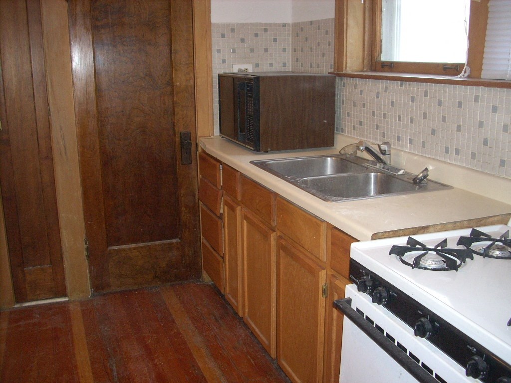 a kitchen with a stove and a sink and a microwave