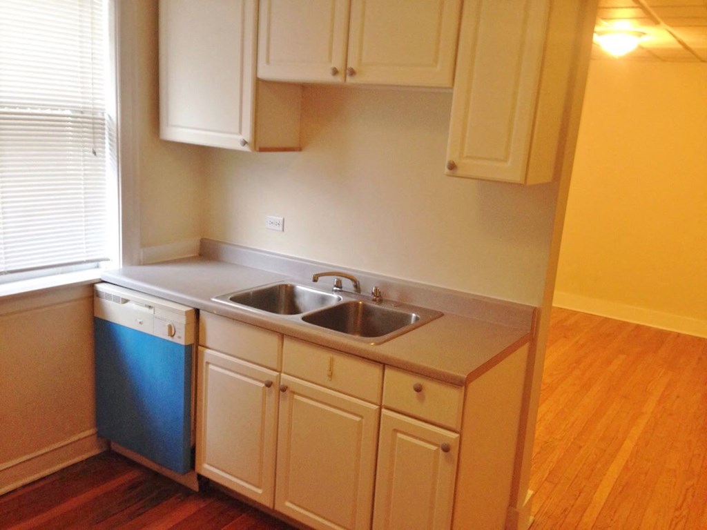 a kitchen with white cabinets and a blue dishwasher