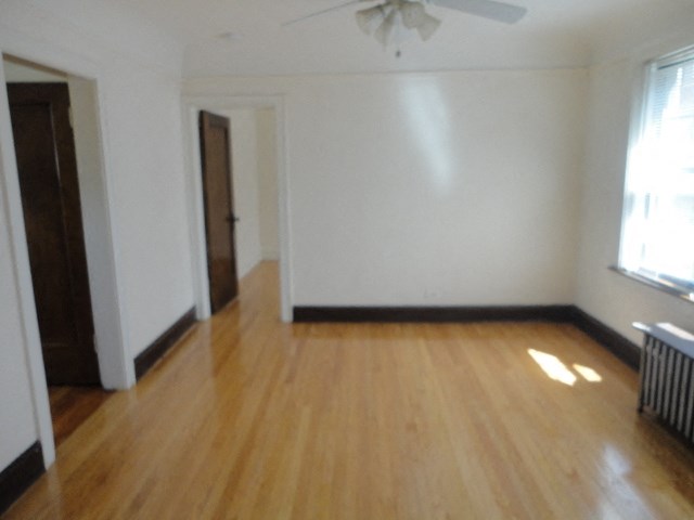 an empty living room with wooden floors and a window