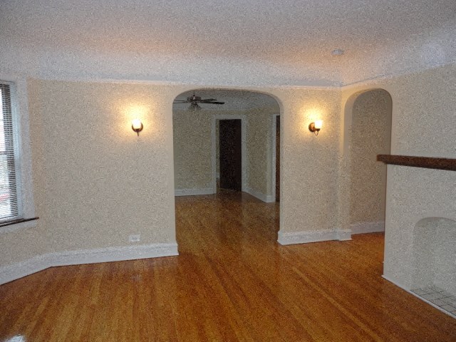 an empty living room with a wooden floor and white walls