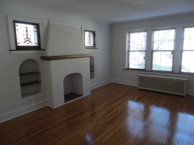 a living room with a fireplace and a wooden floor
