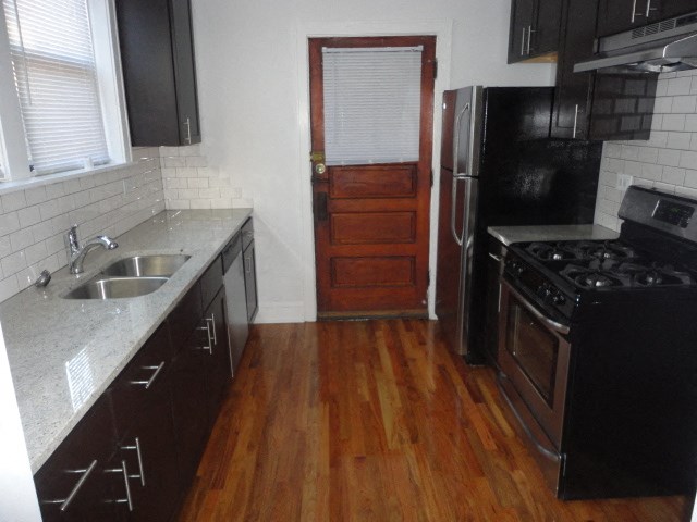 a kitchen with a sink and a refrigerator and a door