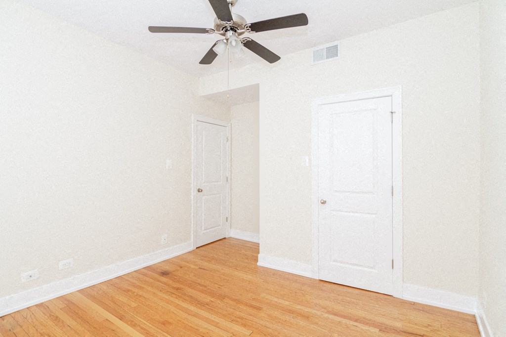 an empty room with a ceiling fan and a closet